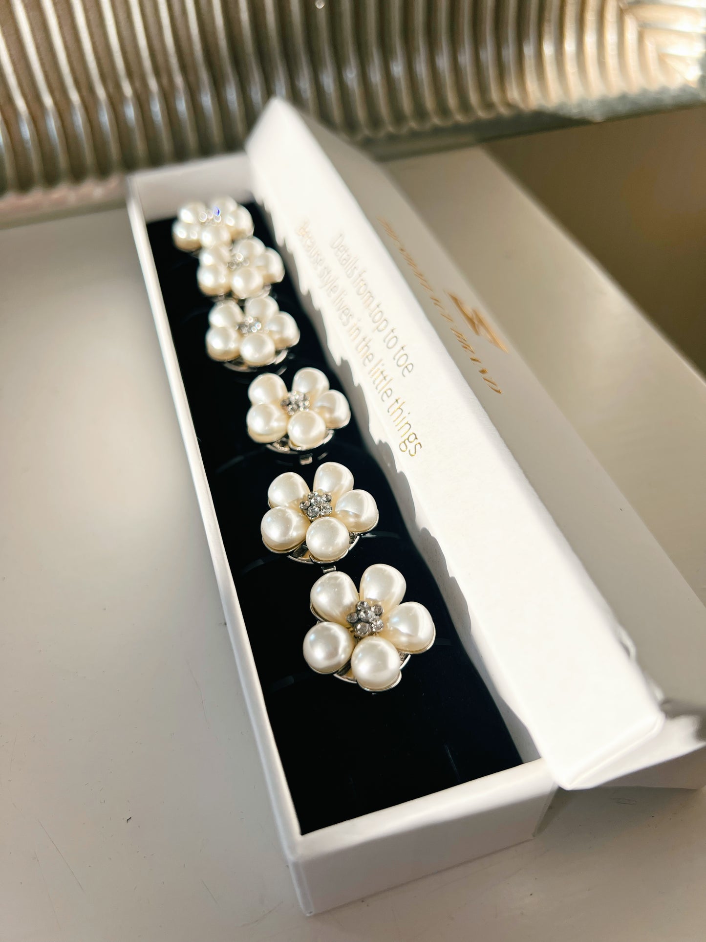 sex stycken vita blomformade button charms i vita pärlor från The Shoelace Brand