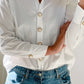Kickan Button Charm on a white shirt, heart shaped white pearl heart with small crystals and gold