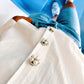 Close up on The Shoelace Brands button charm Rosi, white pearl flower in silver